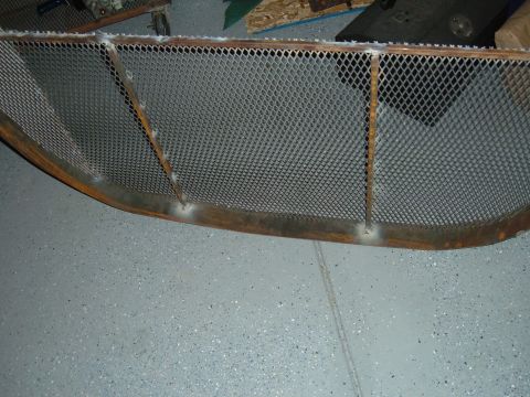 1993 Ford Bronco - A custom-fabricated metal grille with a diamond mesh pattern and visible welds is shown on a garage floor.