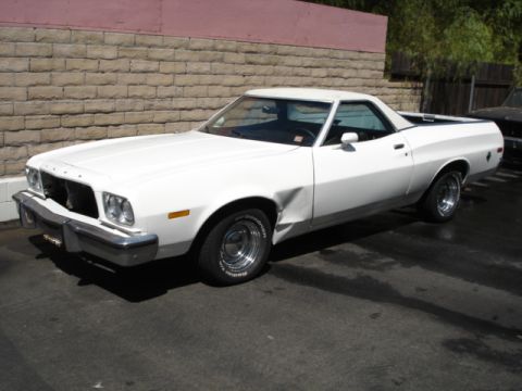 1973 Ford Ranchero - White 1973 Ford Ranchero parked outdoors, showing damage to the front driver's side fender.