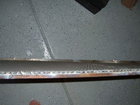 1993 Ford Bronco - A close-up view of a vehicle radiator resting on a speckled garage floor.