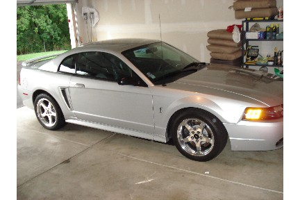 1998 Ford Taurus - Silver Ford Mustang in a garage, showing its side profile and front quarter.