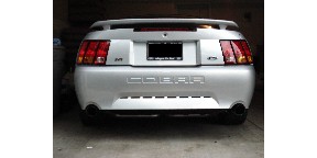 1998 Ford Taurus - Rear view of a silver Ford Mustang Cobra, showing its distinctive taillights and exhaust system.