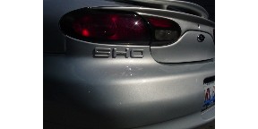 1998 Ford Taurus - The rear of a silver 1998 Ford Taurus SHO is visible, showing its distinctive taillights and spoiler.