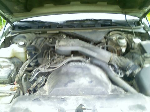 2002 Ford Crown Victoria - The engine bay of a vehicle, showing a complex arrangement of hoses and mechanical parts.