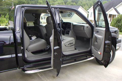 1995 Ford Bronco - Interior view of a black pickup truck with all four doors open, revealing the spacious cabin and seating.