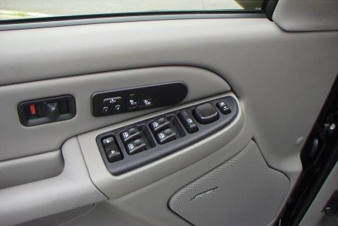1995 Ford Bronco - Close-up of a car's interior door panel, showing window controls and a speaker.