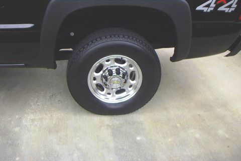 1995 Ford Bronco - Rear wheel and fender detail of a black truck with a 4x4 decal.