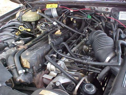 1968 Ford Mustang - Close-up view of an engine bay, showing various mechanical parts and wiring.