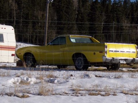 1972 Ford Ranchero - Side view of a yellow 1972 Ford Ranchero pickup truck parked in a winter landscape.