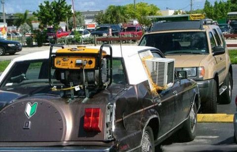 1978 Ford Mustang II - A car is modified with a generator and an air conditioner unit strapped to its exterior.