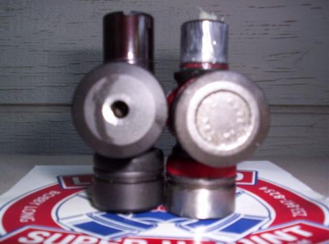 1995 Ford Bronco - Two U-joints are shown, one with a red boot, resting on a Supermotors logo.