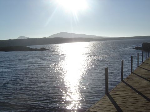 1985 Ford Ranger - A bright, sunny day over the water with a wooden dock in the foreground and hills in the distance.