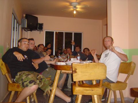 1985 Ford Ranger - A group of friends enjoy a meal together around a rustic wooden table, with a ceiling fan visible overhead.