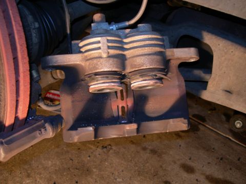 1992 Ford Taurus - Close-up view of a used brake caliper, likely needing replacement.