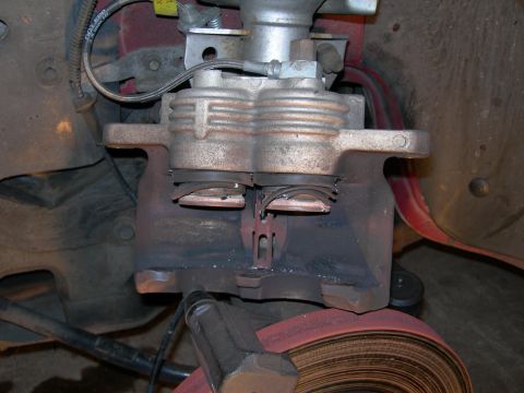 1992 Ford Taurus - This image shows a close-up view of a vehicle's brake caliper and rotor assembly.