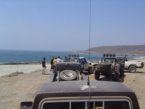 1985 Ford Ranger - Off-road trucks gathered near the coast on a sunny day.
