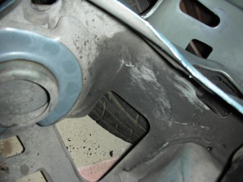 1990 Ford Mustang - Detail shot of an engine bay component, with a tire peeking out from behind.