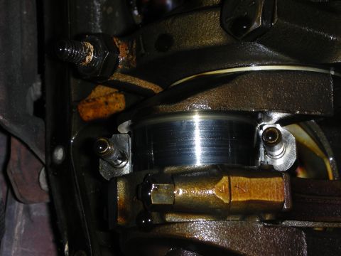 1990 Ford Mustang - Close-up view of an engine's crankshaft bearing and connecting rod, showing signs of wear and oil.