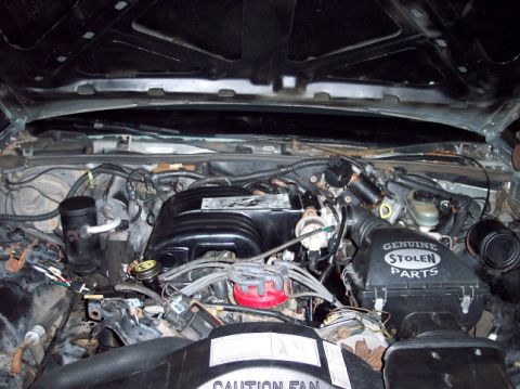 1989 Ford Crown Victoria LTD - The engine bay of a vehicle, showing various mechanical parts and wiring.