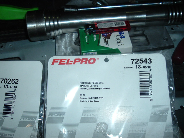 Fel-Pro EGR housing-to-plenum gasket packages for Ford 302 V8 on a workbench