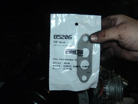 1989 Ford LTD Crown Victoria - Hand holding a sealed Engine Seal Gaskets package, part 85206, containing an EGR valve gasket listed for Ford 4, 6, and V8 engines 1977-90,…