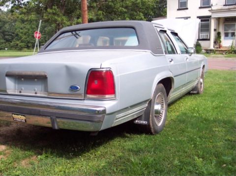 1990 Ford Crown Victoria LTD - This 1990 Ford Crown Victoria LTD is seen from the rear, a vinyl roof and some damage to the trunk lid.