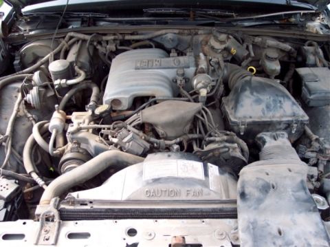 1990 Ford Crown Victoria LTD - Close-up view of a car's engine compartment, showing various mechanical parts and wiring.