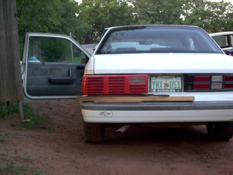 1990 Dodge Shadow - Rear view of a white 1990 Dodge Shadow sedan, an open driver's door and a license plate from Oklahoma.