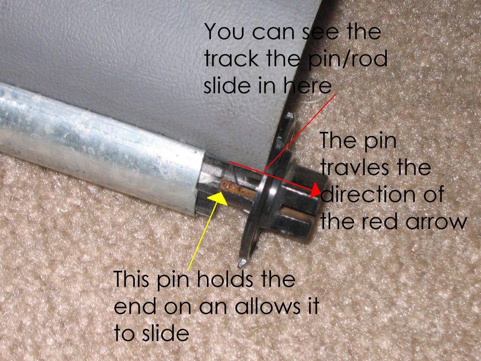 This is the not-fun part, you have to push the black end down and remove the pin.  Much easier said than done.  The springs which push the ends into the side of the vehicle are pretty strong and this would have been much easier with 2 people.  I found the easiest way to do it is to stand it up and push both ends in at the same time and then tap the pin out with a small hammer.  Then you can pull it out with a pair of pliers.  The whole time you do this be careful not to break the black plastic ends and to not bed the rod which the pin is in.  The rod is fairly easy to bend and it will mess things up pretty bad.  Once you have one end off you can then remove the vinyl sheet thing.