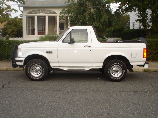 White 1995 Ford Bronco parked on street, side view