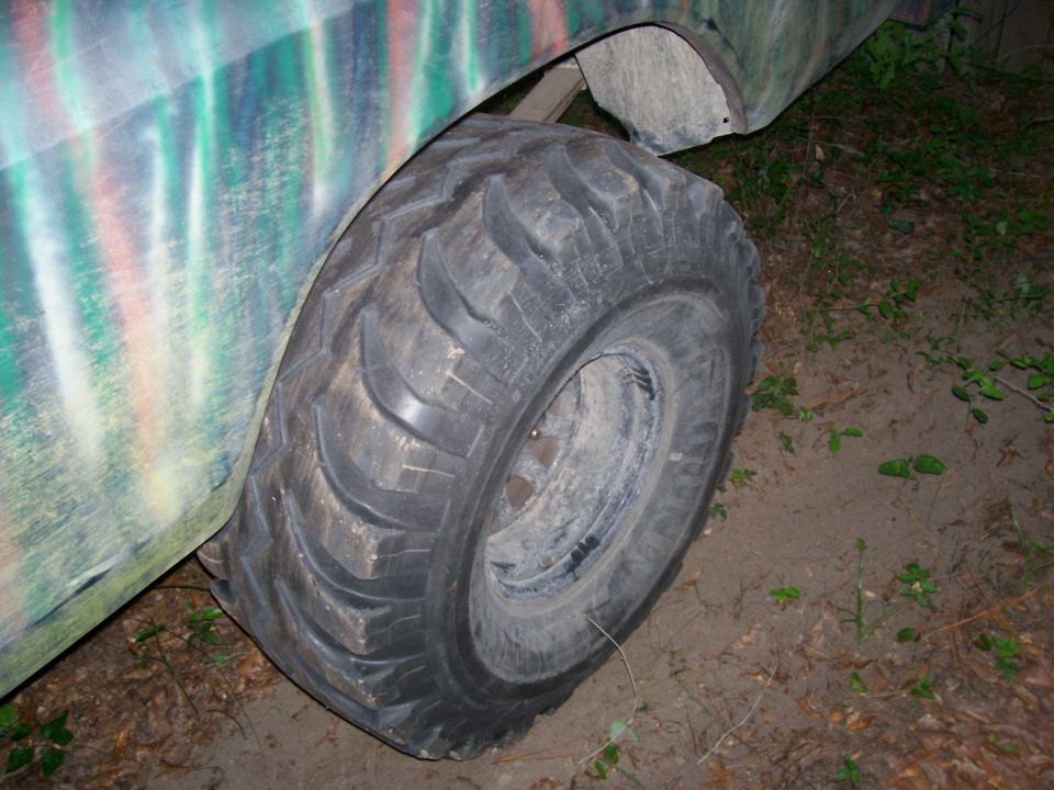 Side view of a large off-road tire on a camouflaged truck