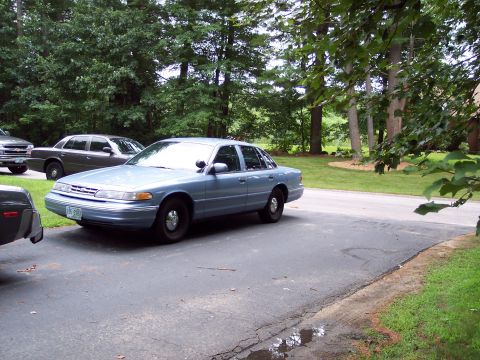 2001 Ford Crown Victoria - Light blue 2001 Ford Crown Victoria sedan parked on a driveway with other vehicles present.