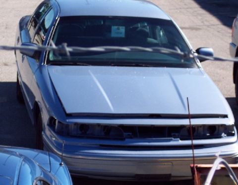 2001 Ford Crown Victoria - A light blue 2001 Ford Crown Victoria is seen from the front with its hood open and a tag on the windshield.
