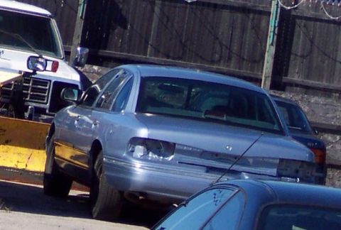 2001 Ford Crown Victoria - Rear view of a blue 2001 Ford Crown Victoria showing damage to the rear end.