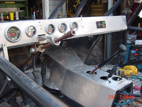 1992 Toyota Tacoma - The interior of a custom-built vehicle features a metal dashboard with several gauges and a prominent gear shifter setup.