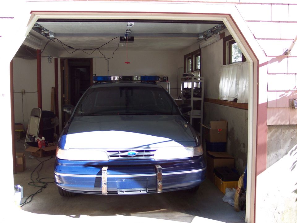 2001 Ford Crown Victoria police car parked inside a garage, front view