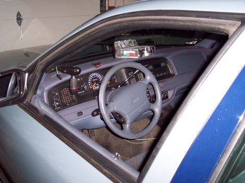 2001 Ford Crown Victoria - Interior view of a 2001 Ford Crown Victoria, showing the dashboard, steering wheel, and police radio equipment.