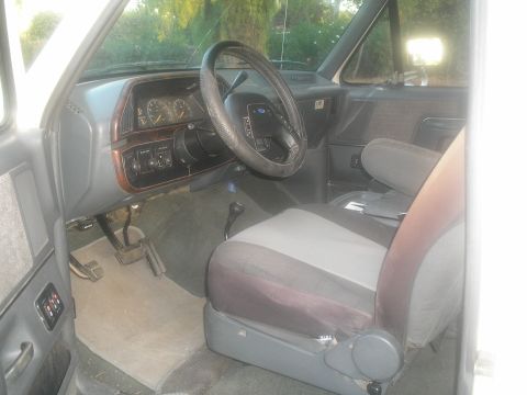 1990 Ford Bronco - Interior of a 1990 Ford Bronco, the dashboard, steering wheel, and front seats.