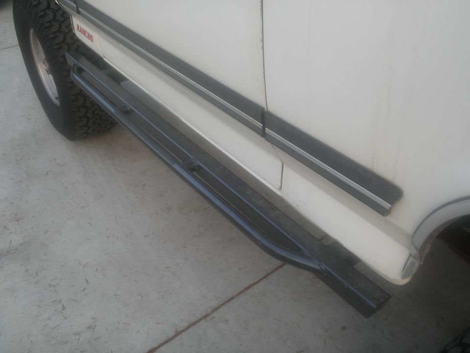 White SUV side panel with black running boards and a partial tire visible