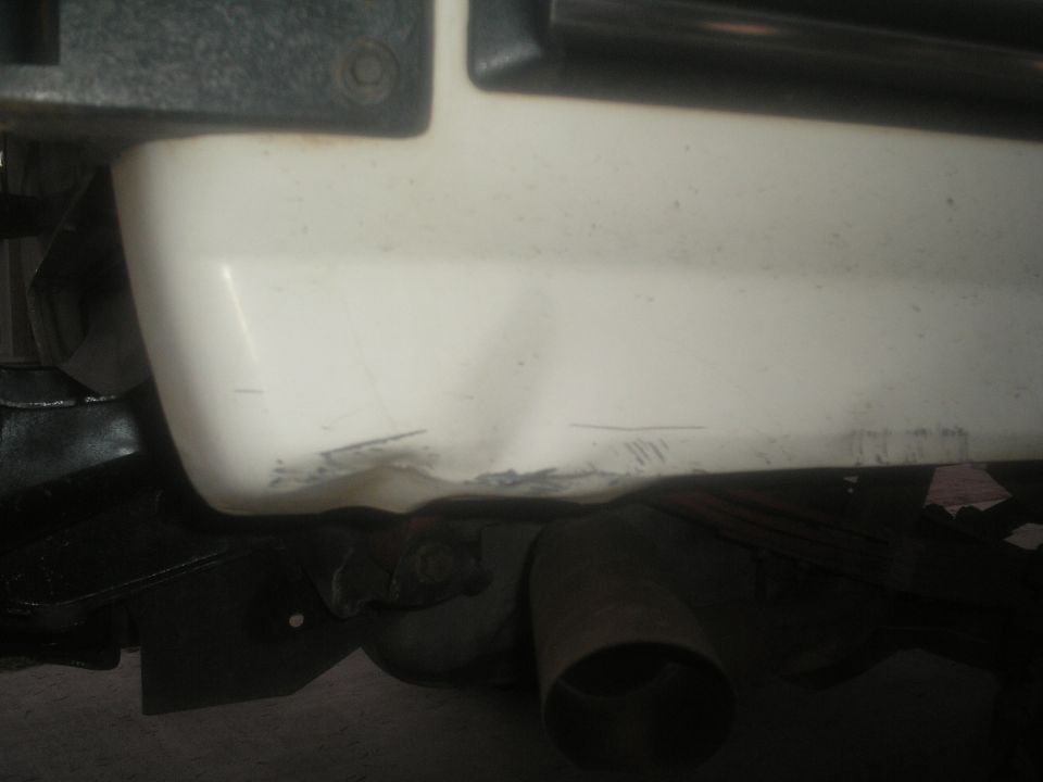 White rear bumper with scuffs and exhaust pipe