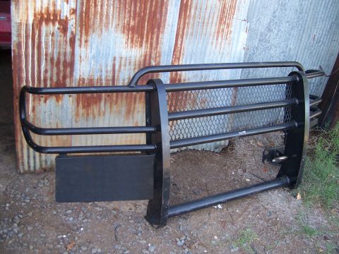 1983 Ford Bronco - A black brushguard with a diamond plate mesh section is shown in front of a corrugated metal wall.