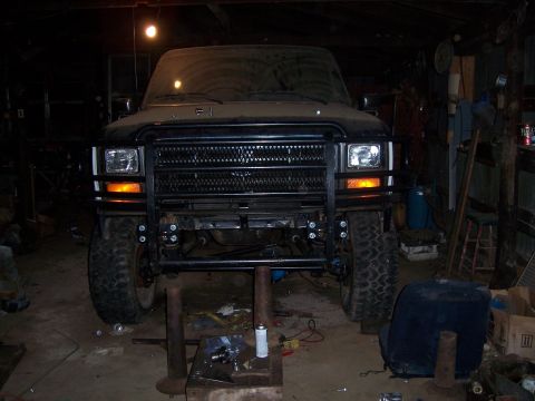1983 Ford Bronco - Front view of a black SUV with a heavy-duty brushguard, elevated on jack stands in a garage.