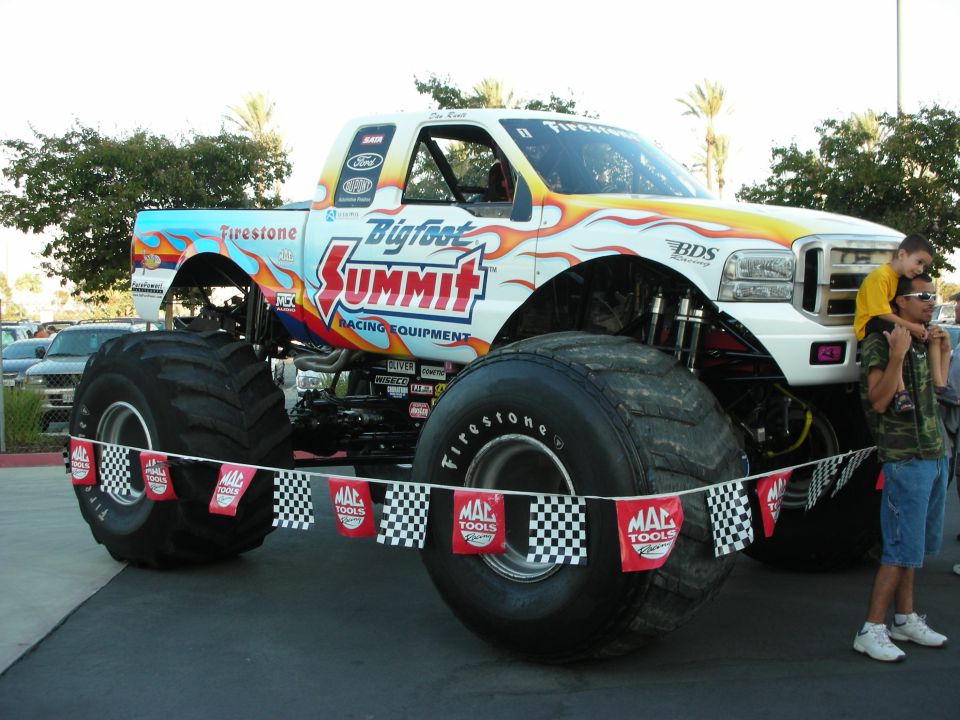 Bigfoot Summit monster truck on display with checkered banner ropes