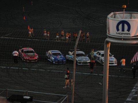 1998 Ford Crown Victoria - Race cars are lined up on a track, with a Mopar sign visible in the foreground.