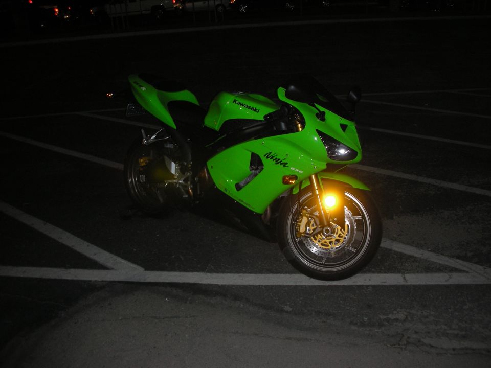 Green Kawasaki Ninja ZX sportbike parked in a lot at night