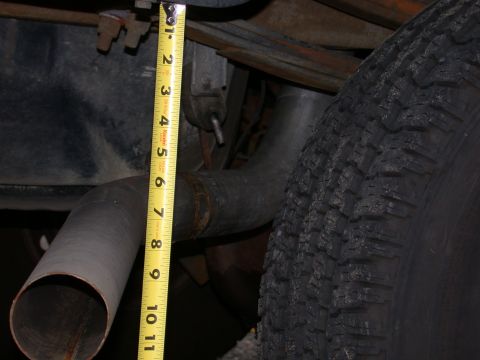 1995 Ford Bronco - A tape measure is shown next to the exhaust pipe and tire of a vehicle.