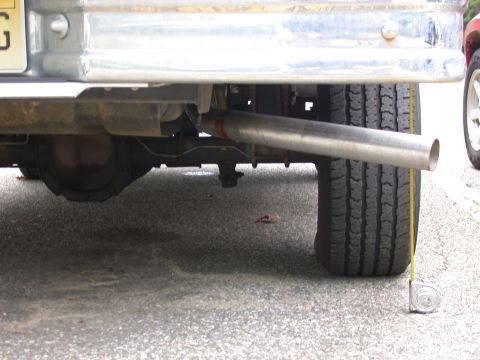 1995 Ford Bronco - Close-up view of a vehicle's rear axle and exhaust pipe, with a tape measure indicating a measurement.