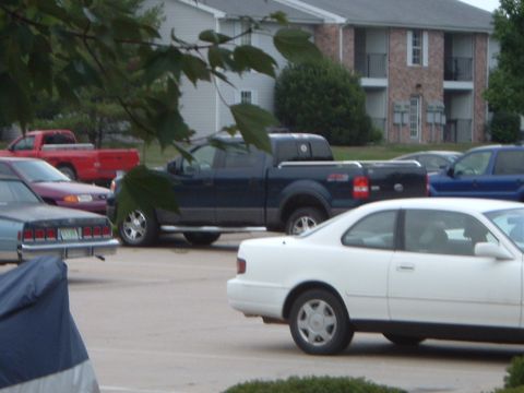 2005 Ford F-150 - A dark blue 2005 Ford F-150 pickup truck is parked in a lot with other vehicles.