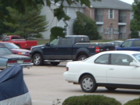 2005 Ford F-150 - A dark blue 2005 Ford F-150 pickup truck is parked in a lot with other vehicles.