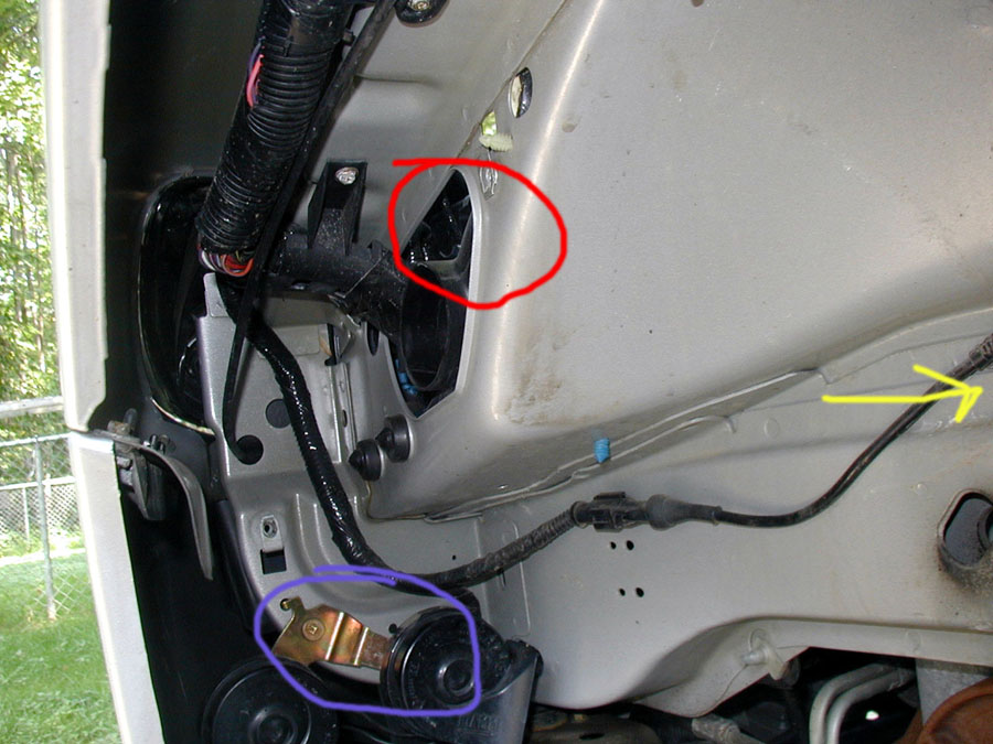 The red area is the air intake.  This is where the silencer was bolted.  For reference, the blue cirle is one of the two horns.  The yellow arrow points to the rear of the car (the shock is just to the right of this picture).