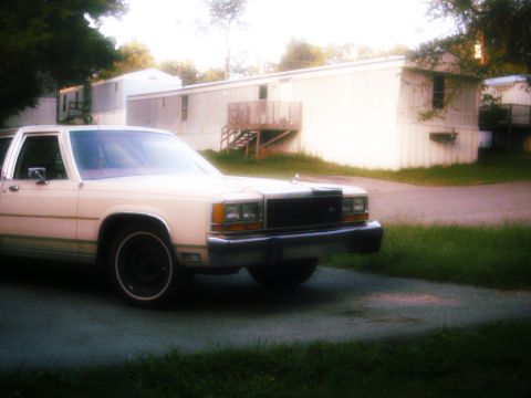 1985 Ford Crown Victoria LTD - This 1985 Ford Crown Victoria LTD is parked outside a row of mobile homes.